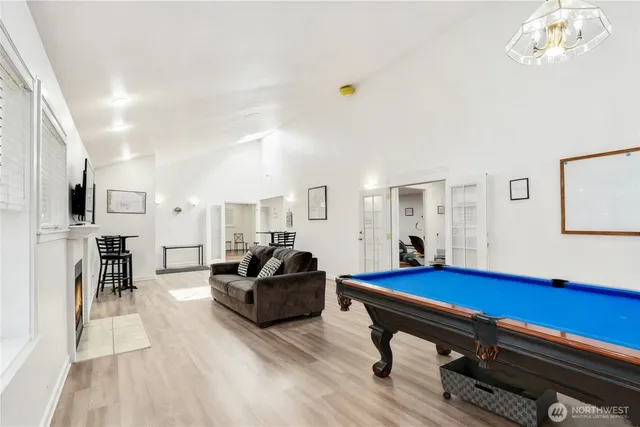 a living room with furniture pool table and window