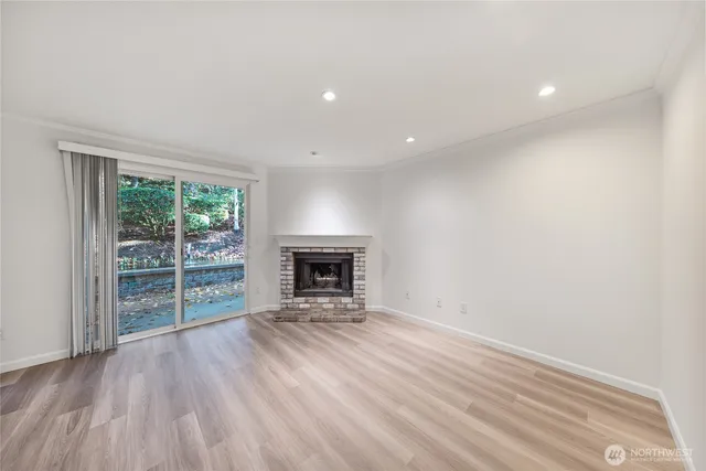 an empty room with floor to ceiling window and fireplace