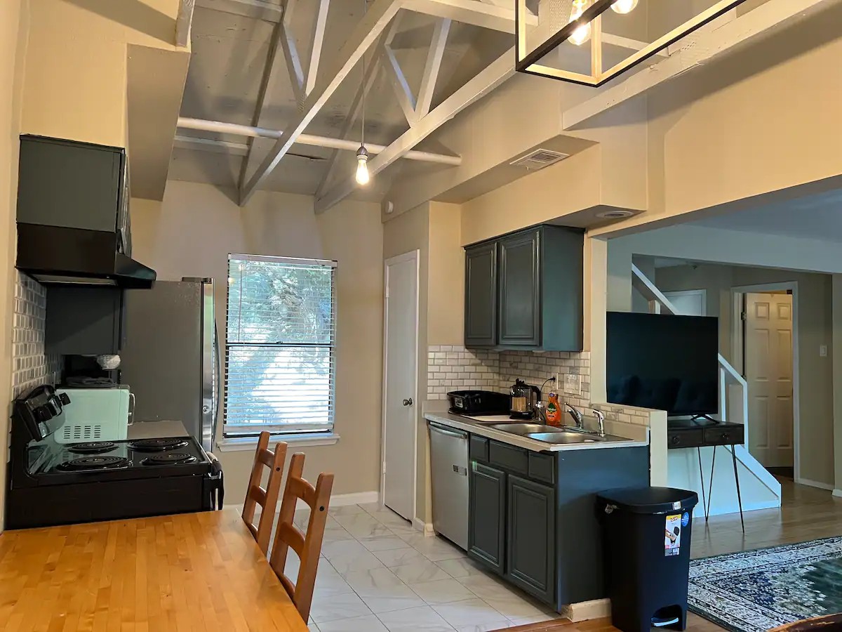 903 The High Road Austin, TX 78746 - Photo 31 of 37 a kitchen with stainless steel appliances kitchen island granite countertop a stove and a sink