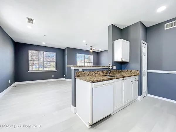a kitchen with granite countertop a sink stainless steel appliances and cabinets