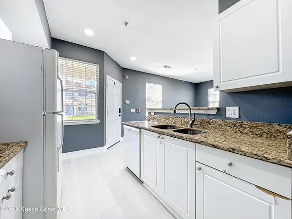a kitchen with granite countertop a sink and cabinets
