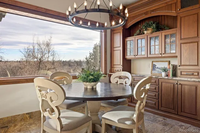 a kitchen with stainless steel appliances kitchen island granite countertop a table chairs and a refrigerator