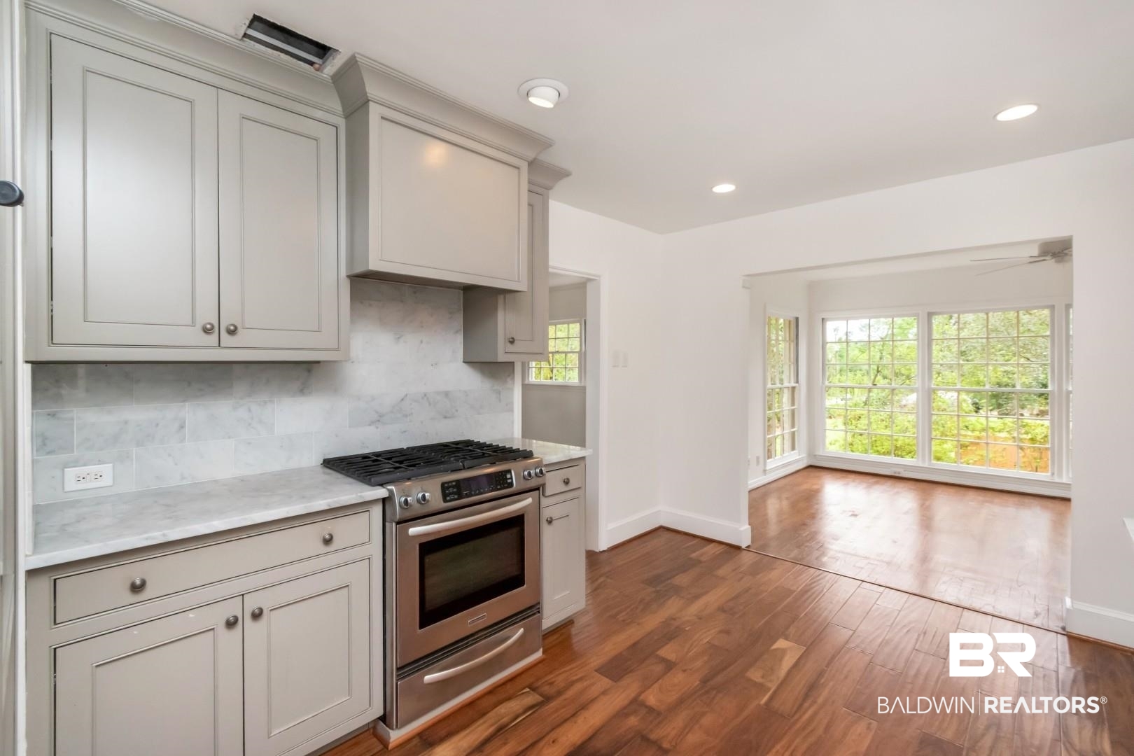 4 Turnout Lane Mobile, AL 36608 - Photo 8 of 53 Kitchen featuring stainless steel range with gas stovetop, dark wood finished floors, decorative backsplash, light stone countertops, and recessed lighting