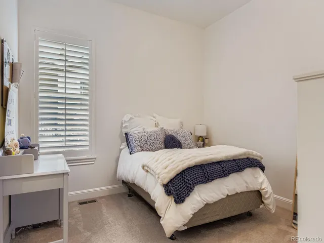a bed sitting in a bedroom next to a window