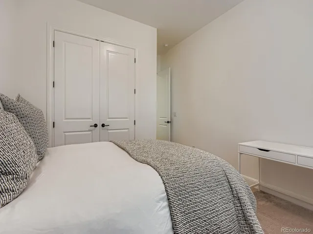 a bedroom with a bed and a white cabinet