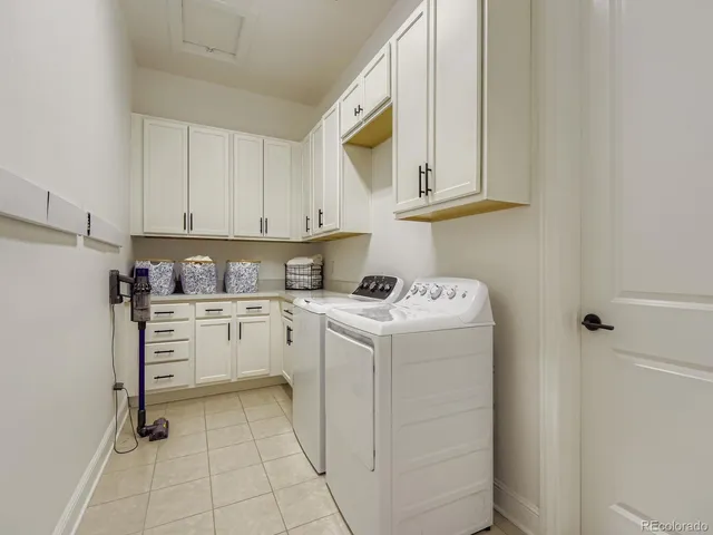 a utility room with cabinets washer and dryer