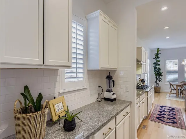 a kitchen with white cabinets and window