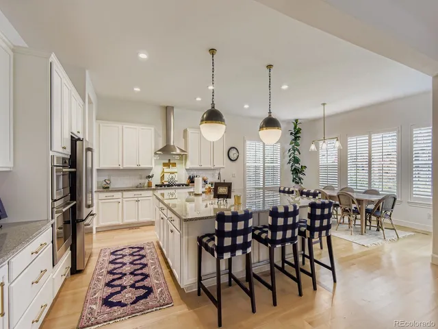 a kitchen with stainless steel appliances a dining table and chairs
