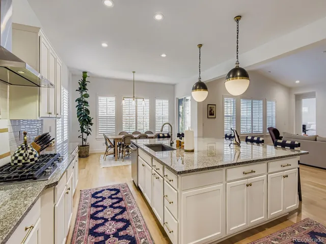 a kitchen with stainless steel appliances a stove a sink a chimney a dining table and chairs