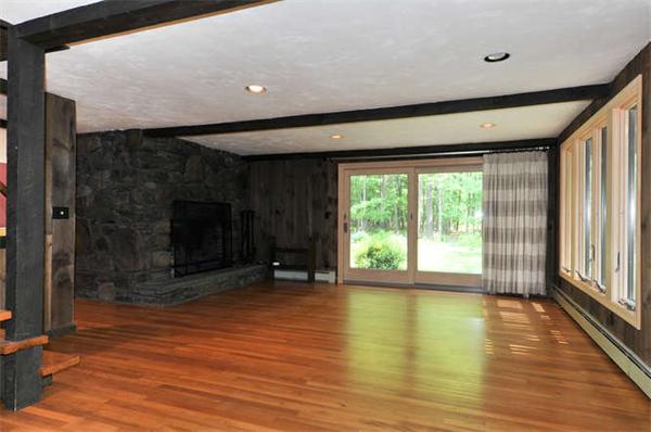 453 Harvard Road Bolton, MA 01740 - Photo 4 of 20 a view of empty room with wooden floor and fireplace