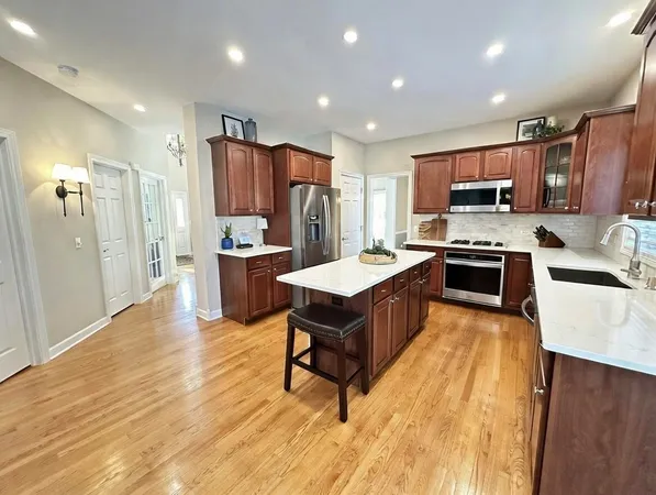 a kitchen with kitchen island a sink a counter top space stainless steel appliances and cabinets
