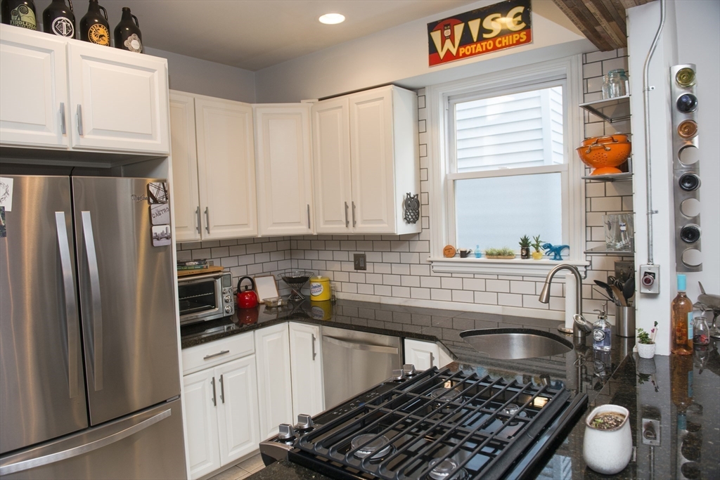 222 Pearl Street, Unit 2 Somerville, MA 02145 - Photo 5 of 15 a kitchen with stainless steel appliances granite countertop a refrigerator a stove and a sink