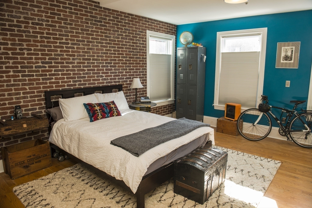 222 Pearl Street, Unit 2 Somerville, MA 02145 - Photo 6 of 15 a bedroom with a bed and wooden floor