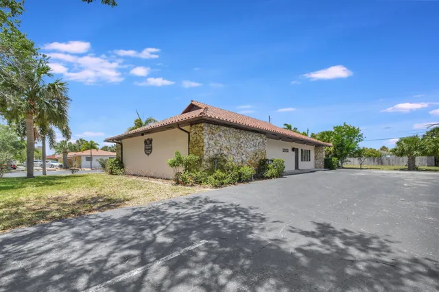 a view of a house with a big yard and large tree