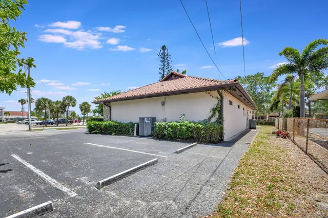 a front view of a house with a yard and potted plants