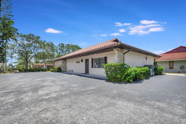 a view of a house with a yard and potted plants