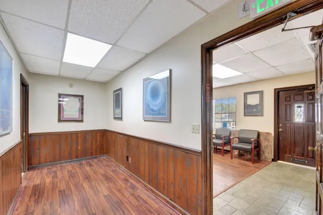 a view of a hallway with furniture and workspace