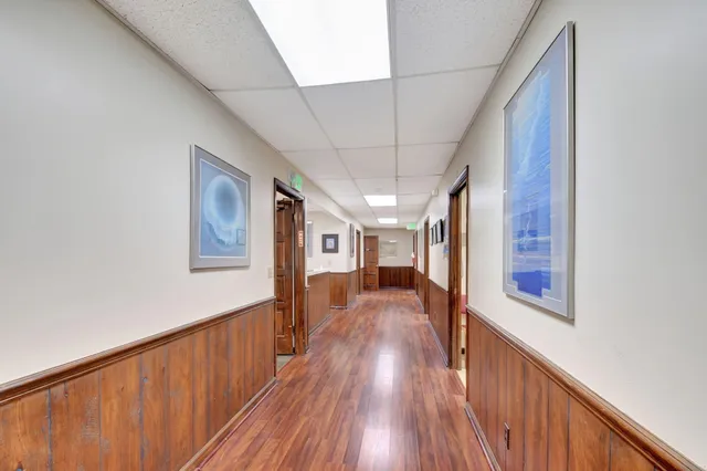 a view of a hallway with wooden floor and staircase