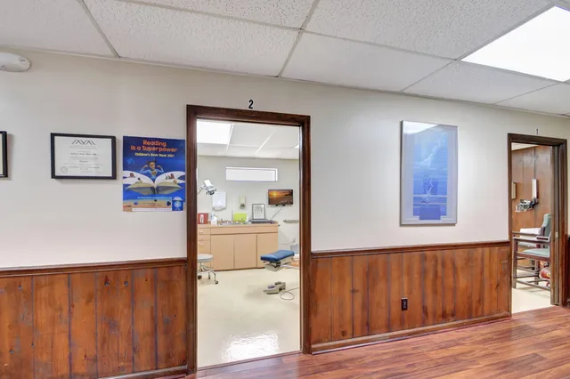 a hallway with painting on the wall and wooden floor