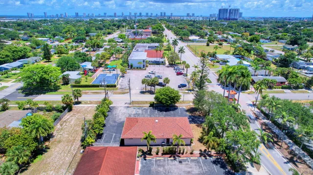 a sign board with a water fountain and a tree