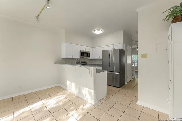 a kitchen with a refrigerator and a stove top oven