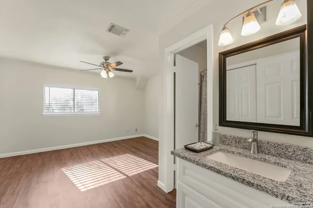 a bathroom with a granite countertop sink and a mirror