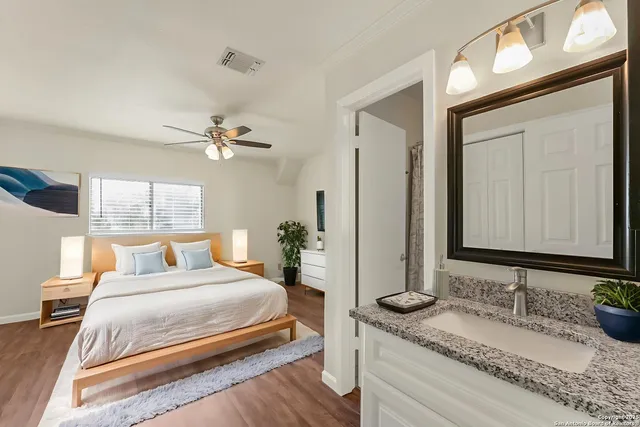 a bedroom with a granite countertop sink and a mirror
