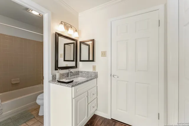 a bathroom with a granite countertop sink a mirror and a bathtub