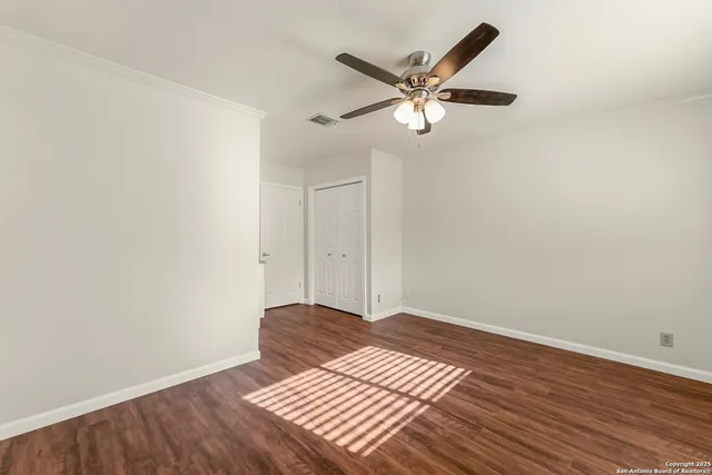a view of a room with wooden floor and white walls