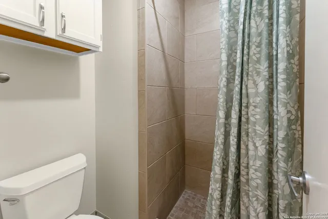 a bathroom with a toilet and shower