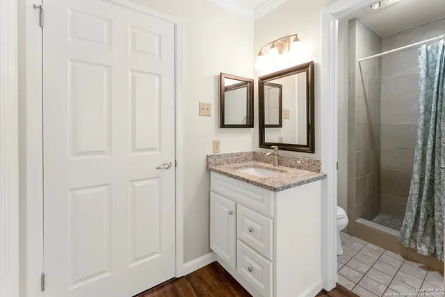 a bathroom with a granite countertop sink and a mirror