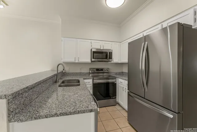 a kitchen with granite countertop a refrigerator and a sink