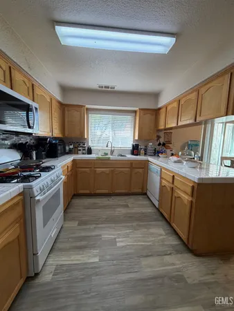a large kitchen with stainless steel appliances granite countertop a stove a sink dishwasher and a refrigerator