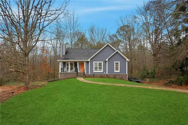 a front view of a house with yard and green space