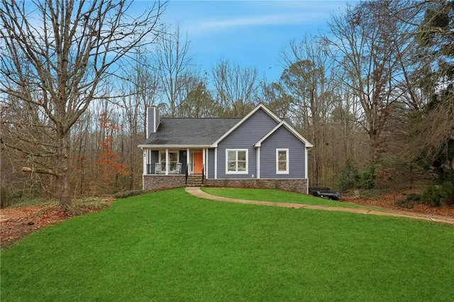a front view of a house with yard and green space