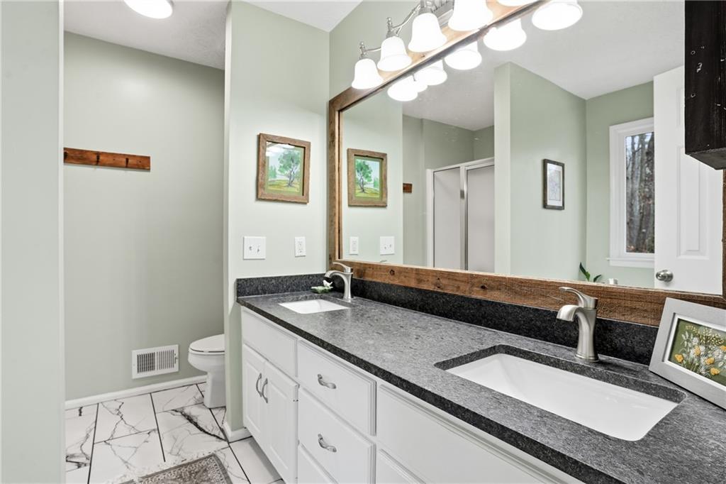 125 Cardinal Court Covington, GA 30016 - Photo 17 of 37 a bathroom with a granite countertop sink and a mirror