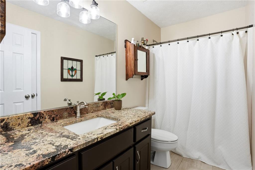 125 Cardinal Court Covington, GA 30016 - Photo 21 of 37 a bathroom with a granite countertop sink and a mirror