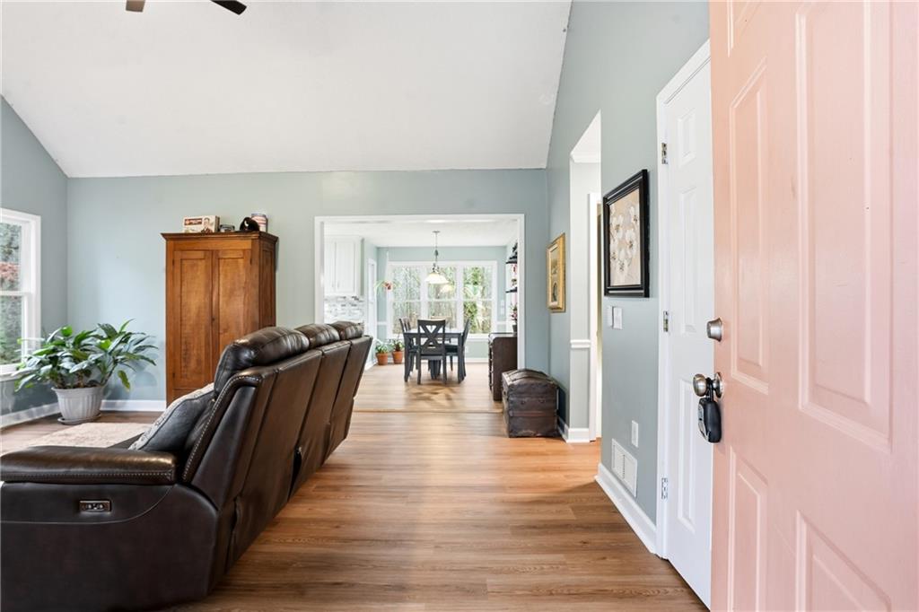 125 Cardinal Court Covington, GA 30016 - Photo 6 of 37 a hallway with a potted plant on a dresser and a wooden floor