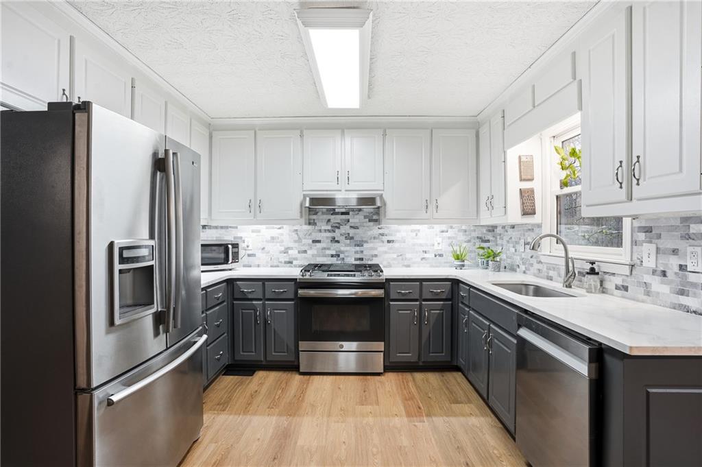 125 Cardinal Court Covington, GA 30016 - Photo 10 of 37 a kitchen with stainless steel appliances granite countertop a sink stove and refrigerator