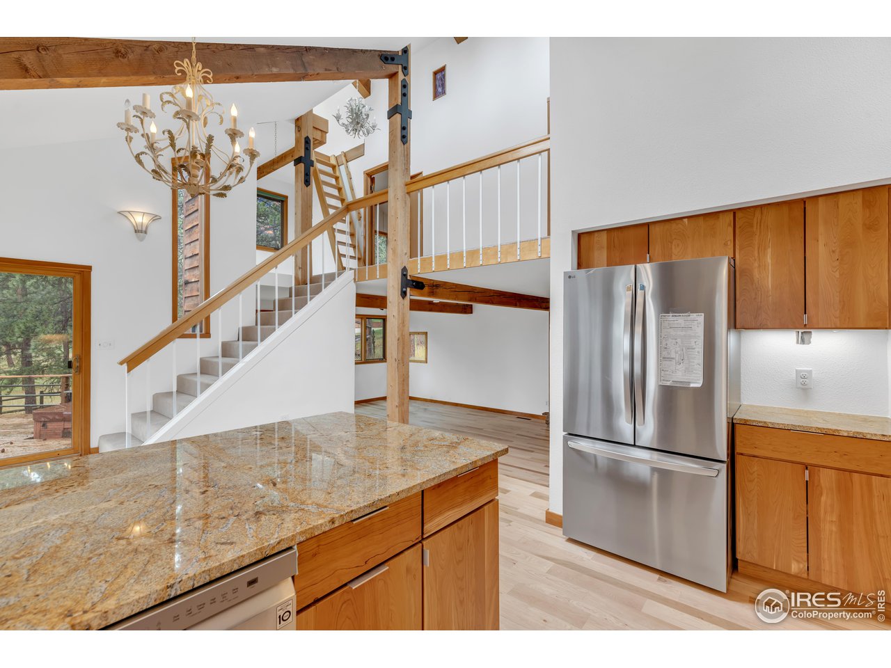 926 Mountain Meadows Road Boulder, CO 80302 - Photo 11 of 38 a kitchen with stainless steel appliances kitchen island granite countertop a refrigerator a stove and a sink with wooden floor