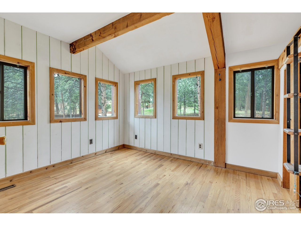 926 Mountain Meadows Road Boulder, CO 80302 - Photo 20 of 38 a view of an empty room with wooden floor and windows