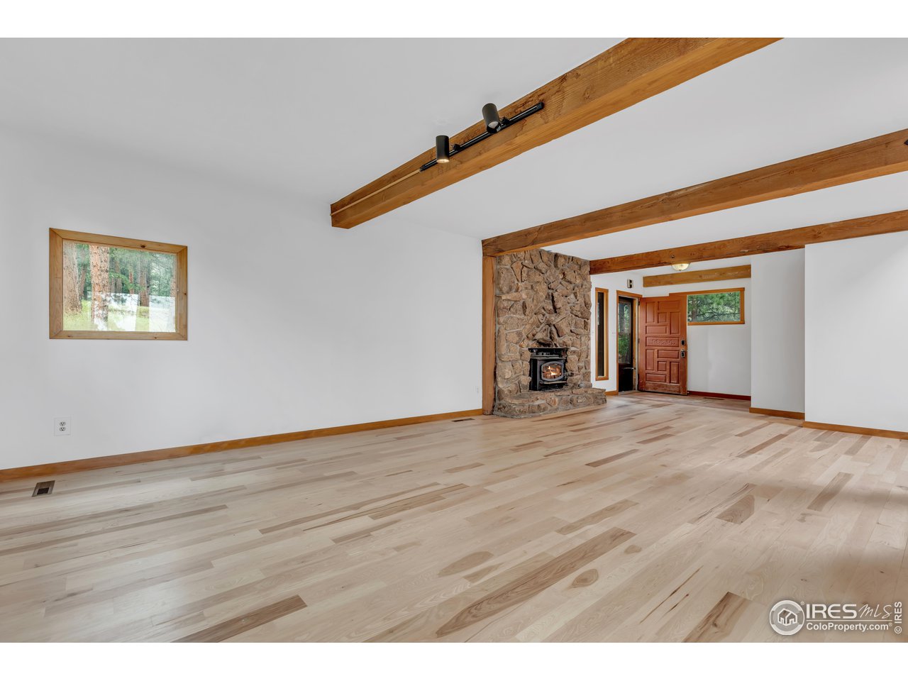 926 Mountain Meadows Road Boulder, CO 80302 - Photo 7 of 38 a view of an empty room with wooden floor and a ceiling fan