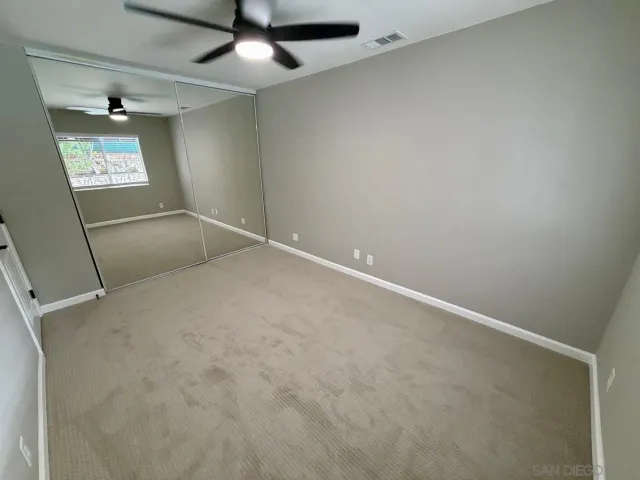 an empty room with windows and fan