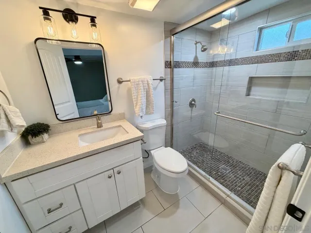a bathroom with a sink a toilet and shower