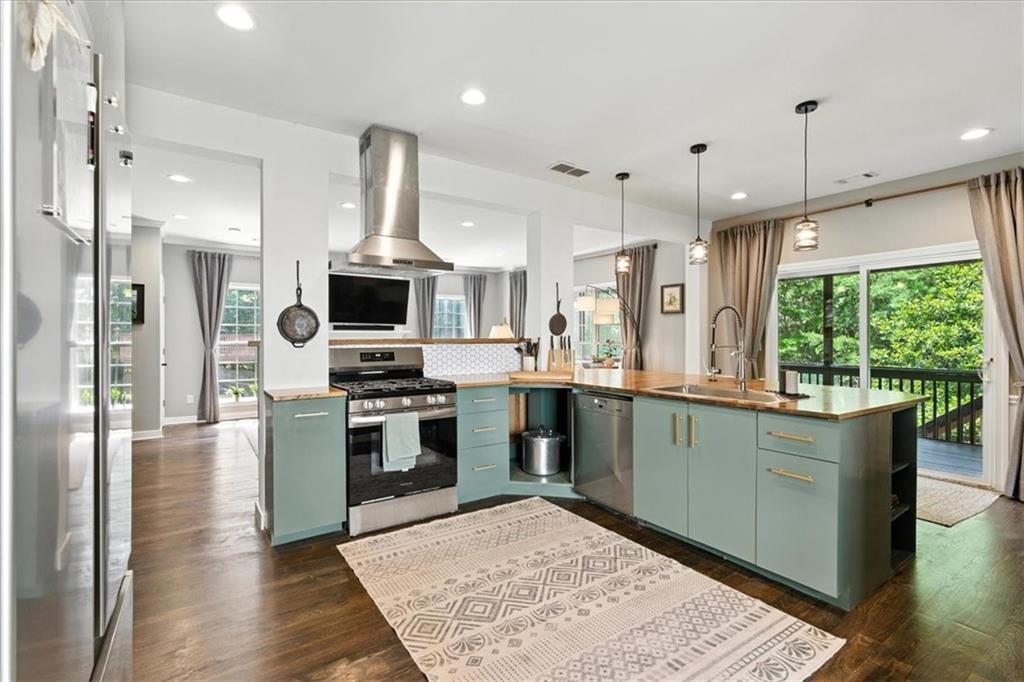 120 Quarrington Court Milton, GA 30004 - Photo 14 of 48 a kitchen with stainless steel appliances granite countertop a stove top oven a sink dishwasher a refrigerator and a dining table with wooden floor