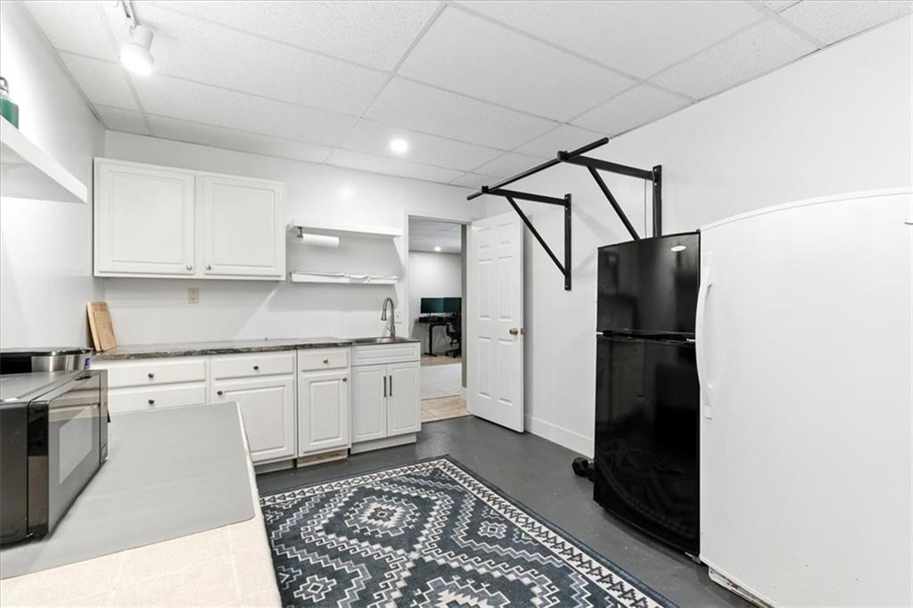 120 Quarrington Court Milton, GA 30004 - Photo 34 of 48 a kitchen with a refrigerator and white cabinets