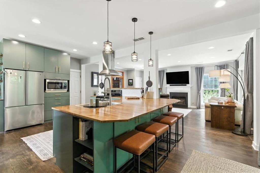 120 Quarrington Court Milton, GA 30004 - Photo 10 of 48 a dining room with stainless steel appliances kitchen island granite countertop a table chairs and a refrigerator