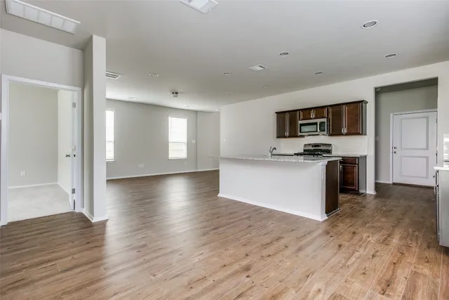a view of kitchen with microwave refrigerator and cabinets