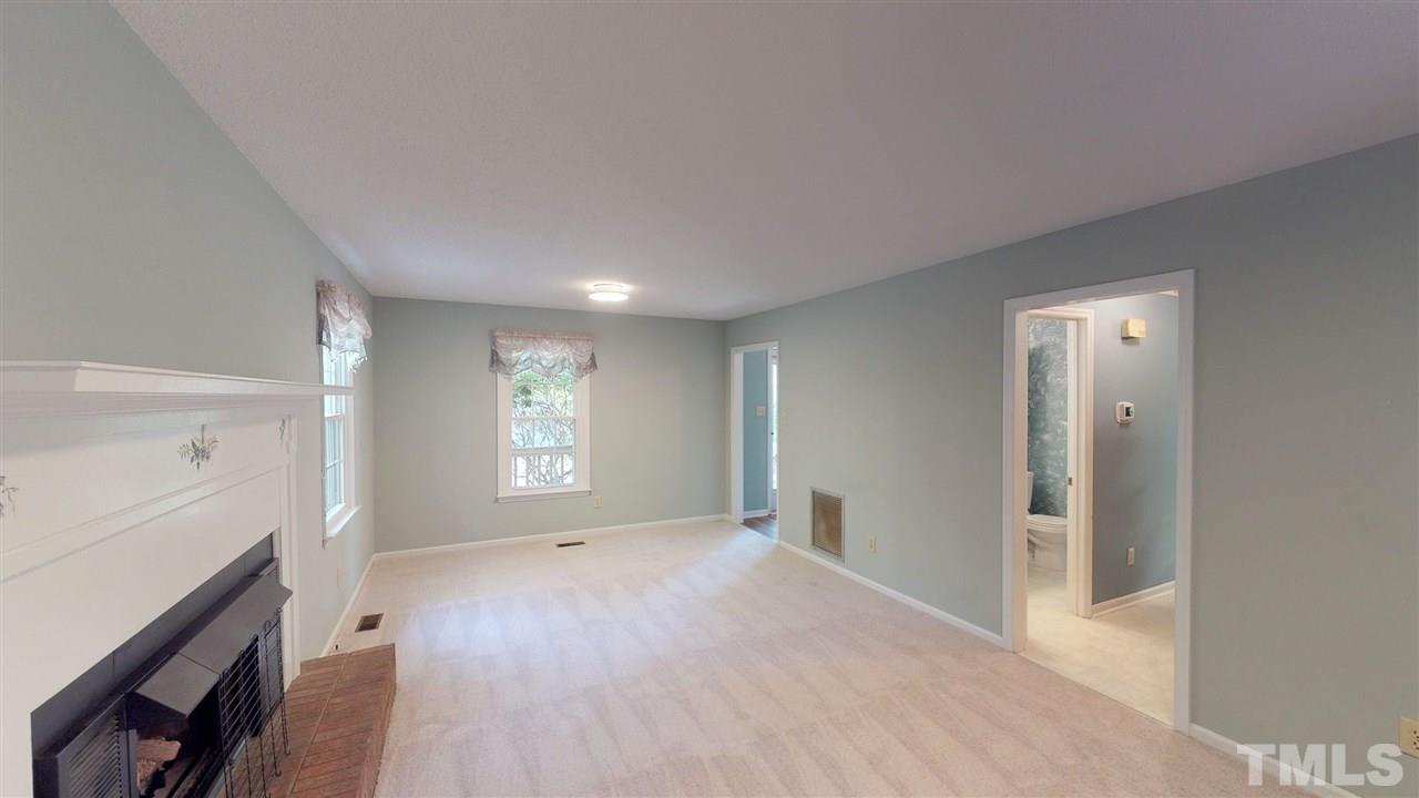 5905 Crabapple Road Durham, NC 27712 - Photo 3 of 30 a view of empty room with a fireplace and wooden floor