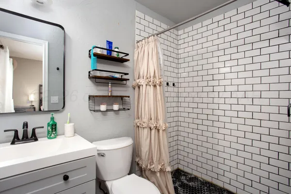 a bathroom with a sink a toilet and shower curtain